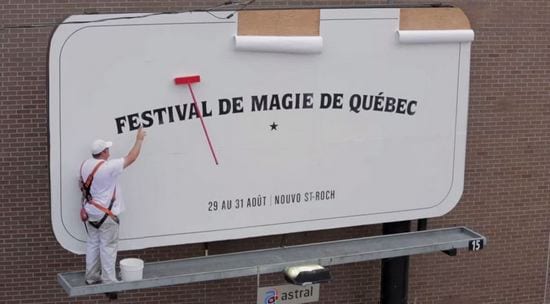 В Квебеке заколдованная щётка монтажника сама разглаживала рекламный постер